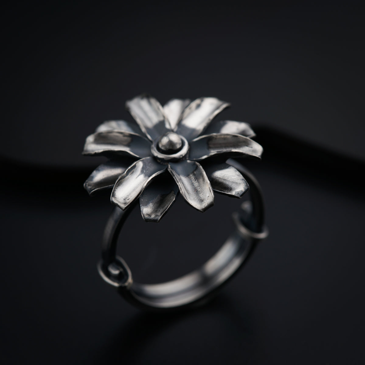 a silver ring with a flower design on it