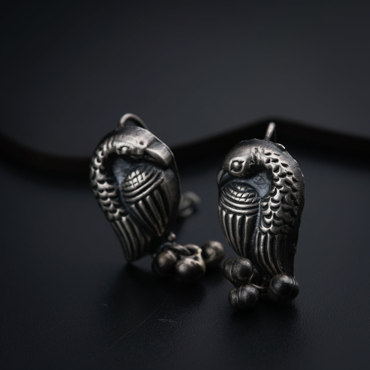 a pair of owl shaped earrings sitting on top of a table