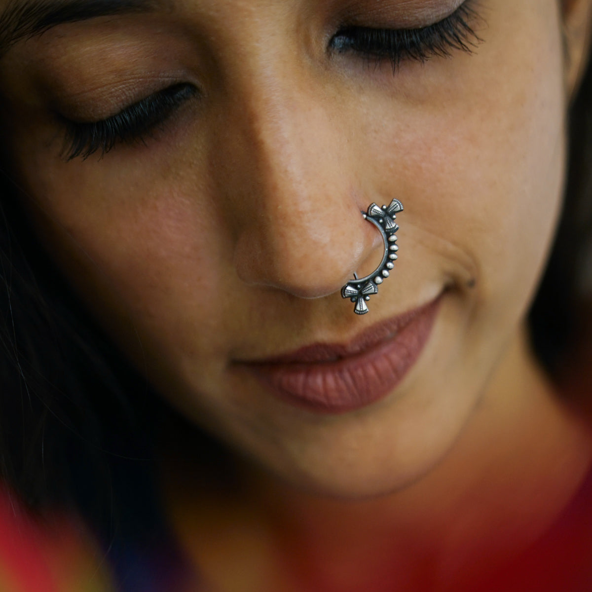 a close up of a woman with a nose piercing