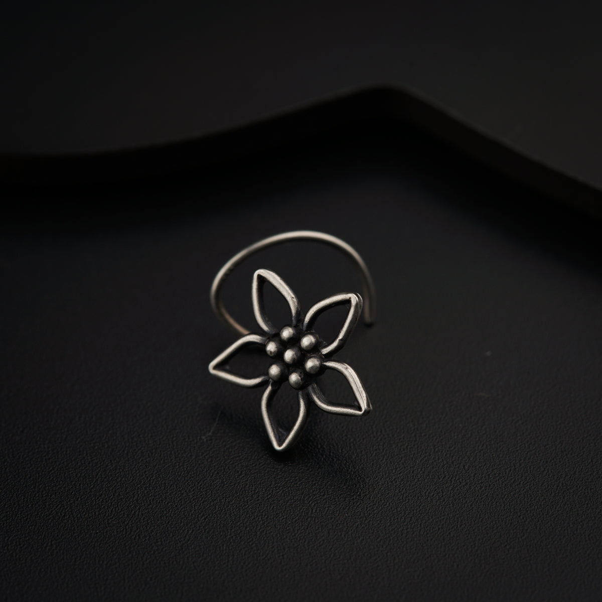 a flower ring sitting on top of a black surface