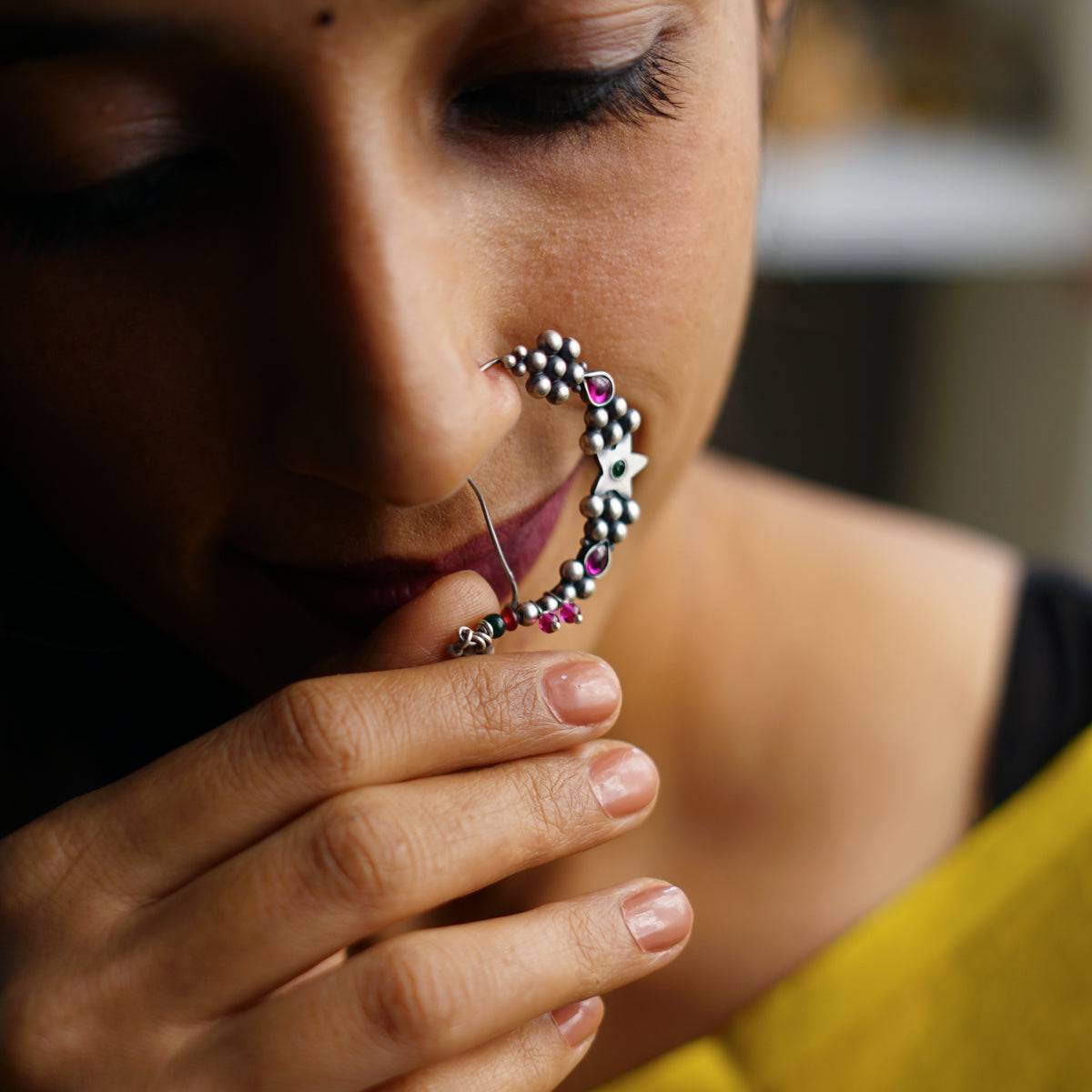 a woman wearing a nose ring with a star on it