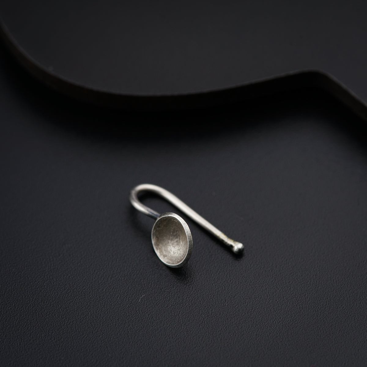 a pair of silver spoons sitting on top of a black surface