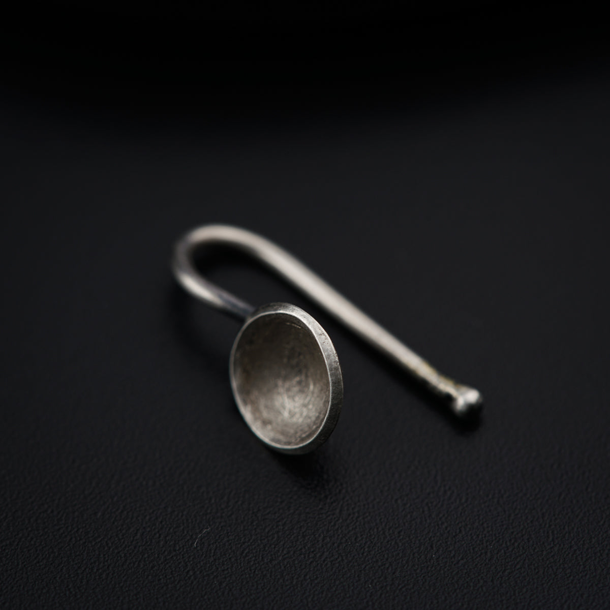 a pair of silver spoons sitting on top of a black surface