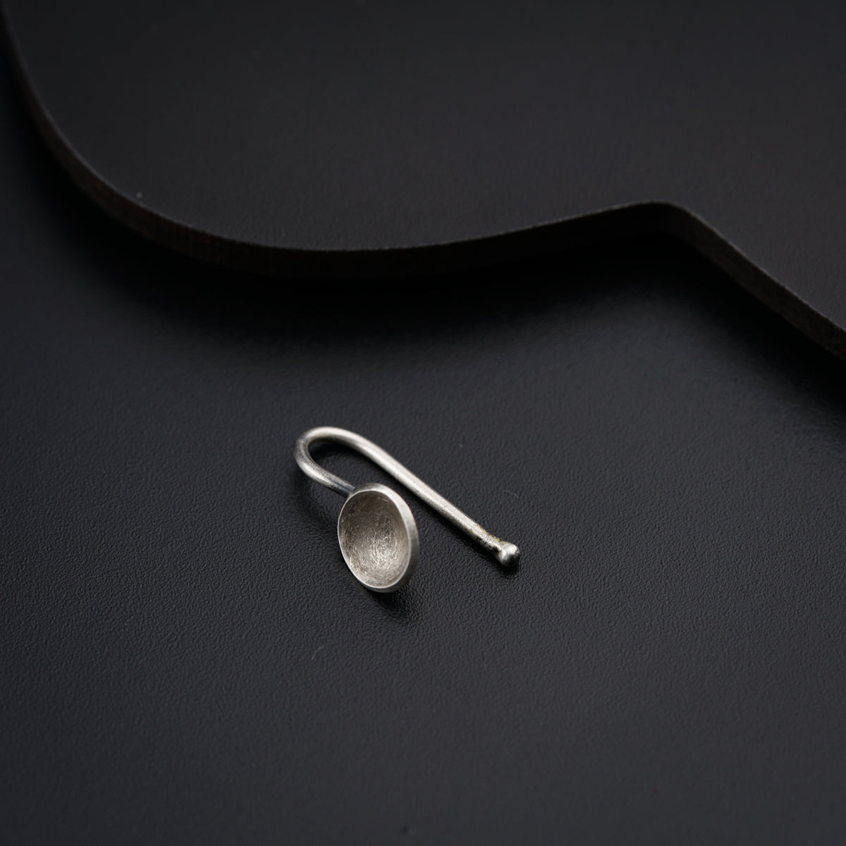 a pair of silver spoons sitting on top of a black surface