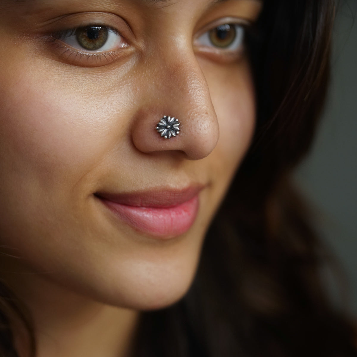 a close up of a woman with a nose piercing