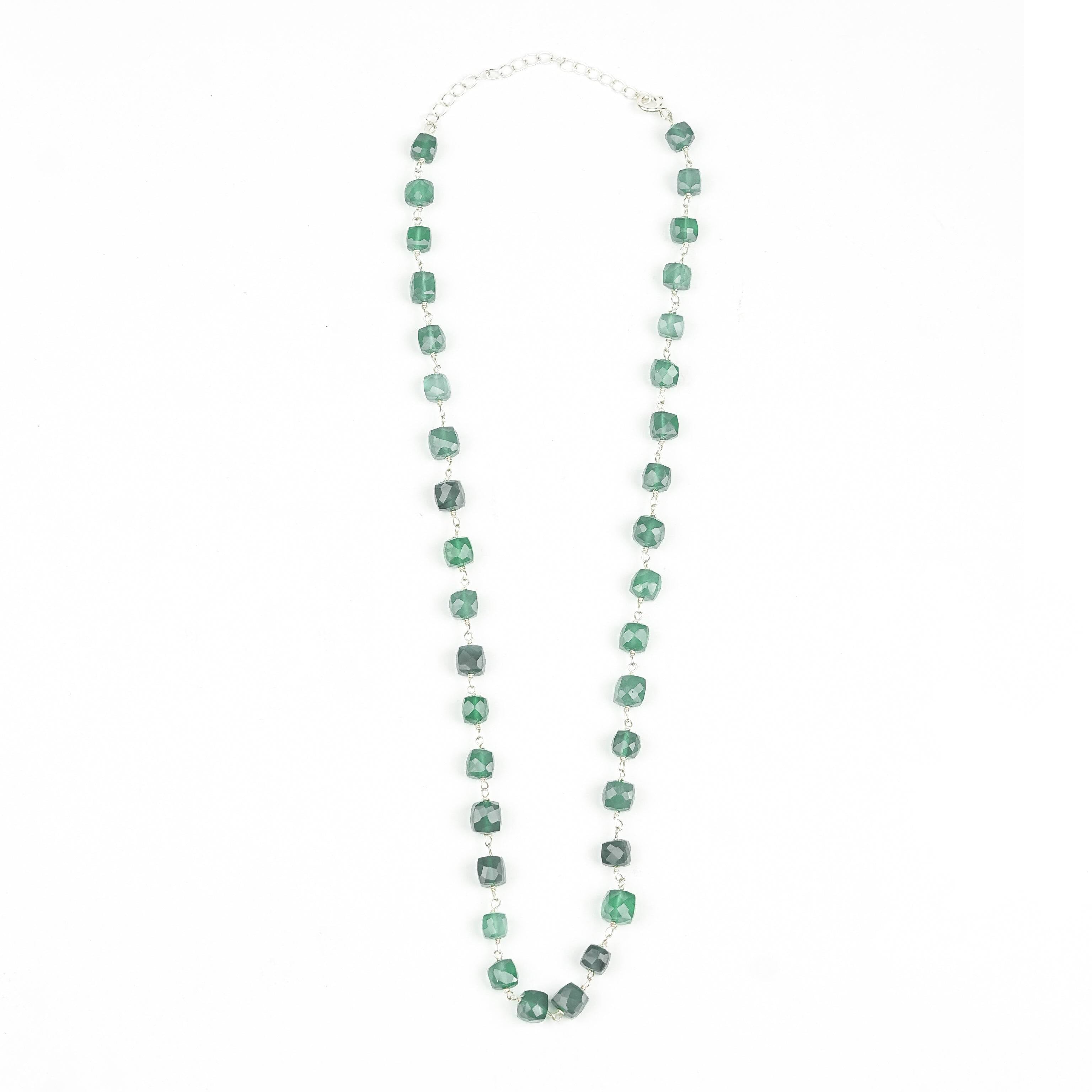 Flat-lay of a silver-green onyx Ganthan Necklace with complementary silver jewellery and traditional accessories