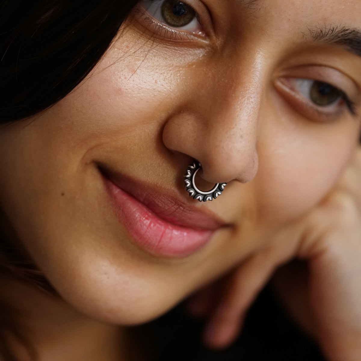 a close up of a woman with a nose ring