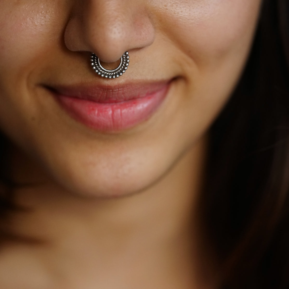 a close up of a woman with a nose ring