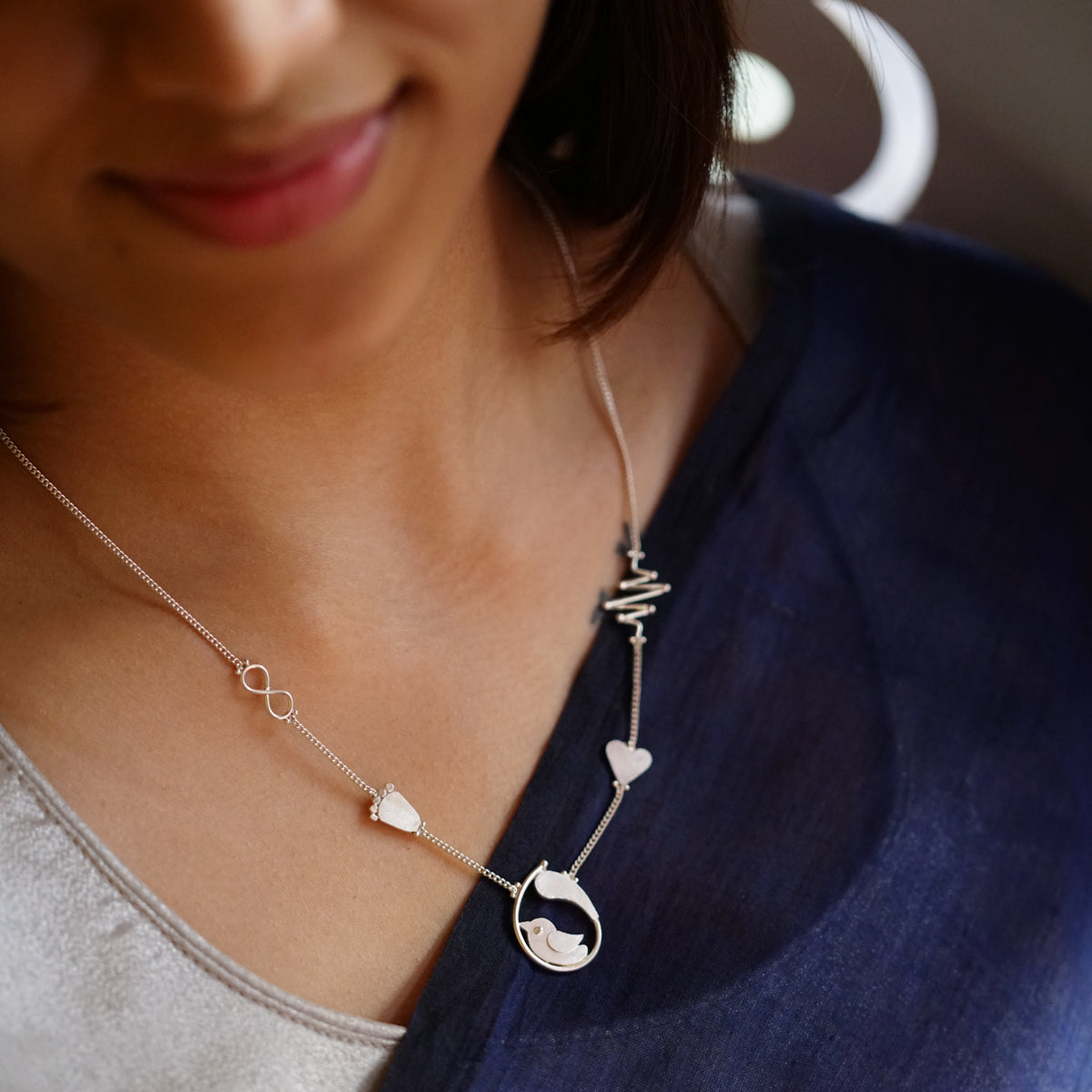 a woman wearing a necklace with a heart on it