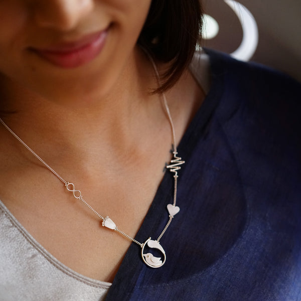 a woman wearing a necklace with a heart on it