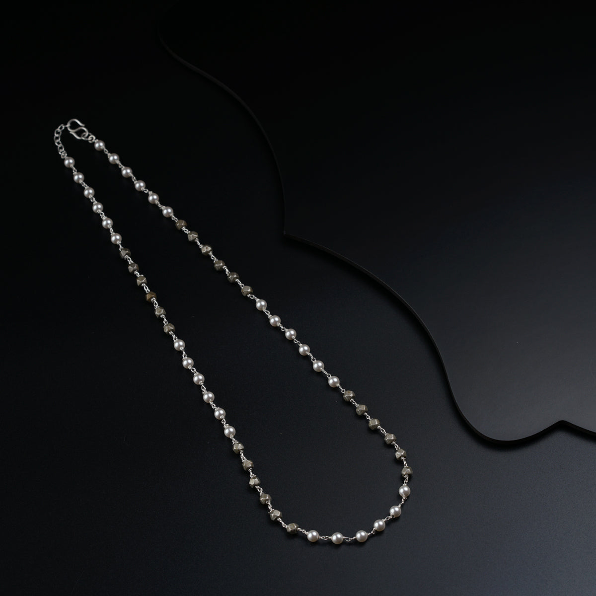 a long silver chain with a clasp on a black background