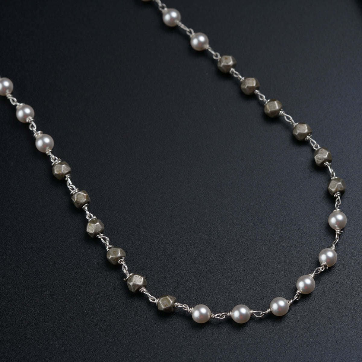 a long necklace with pearls and silver beads