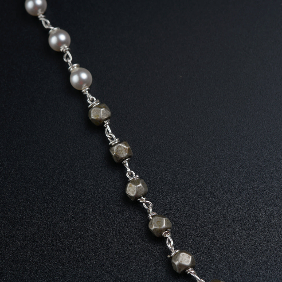 a silver chain with a bunch of pearls on it