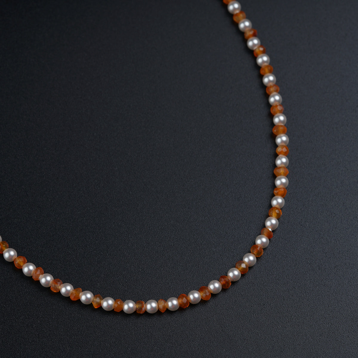 a beaded necklace with silver and orange beads