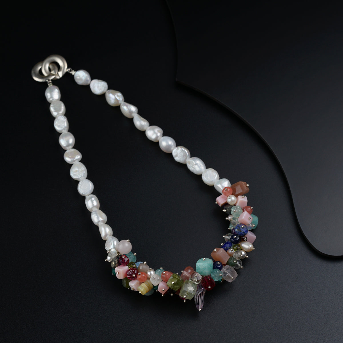 a multi - colored beaded necklace on a black surface