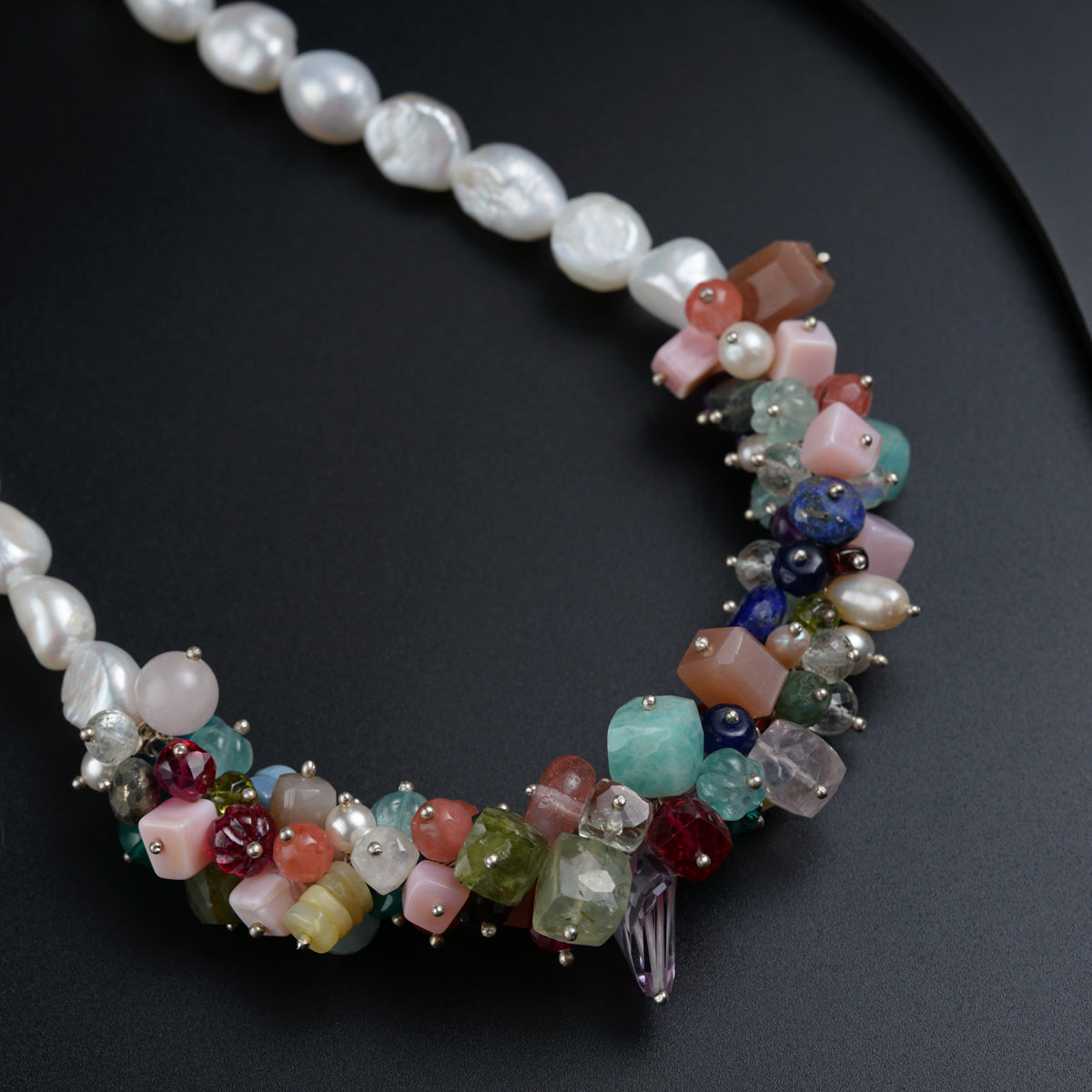 a multi - colored beaded necklace on a black surface