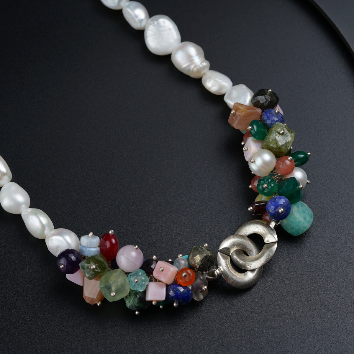 a multi - colored beaded necklace on a black surface