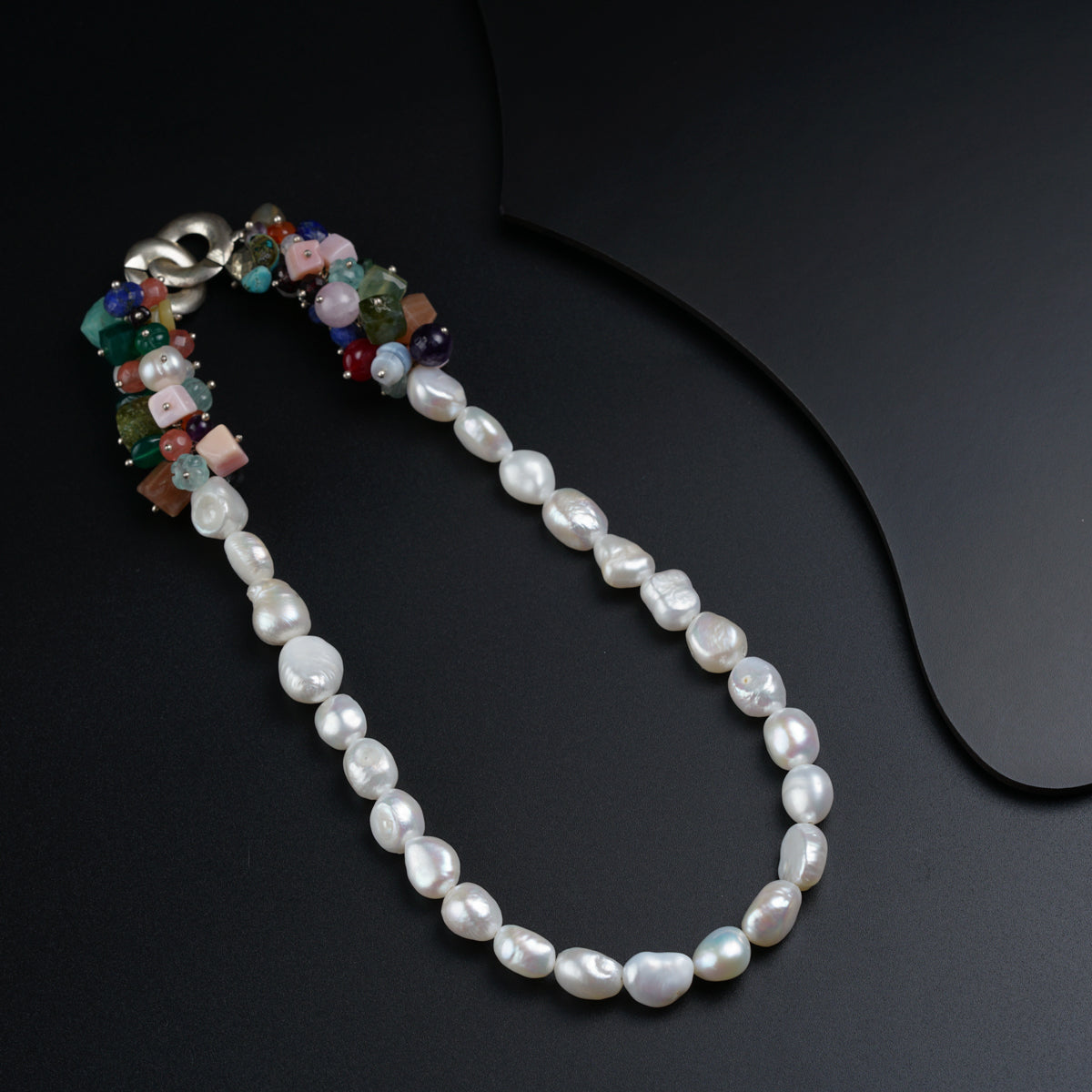 a white pearl necklace on a black surface