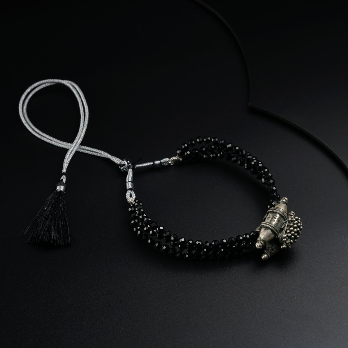 a black beaded bracelet with a tassel