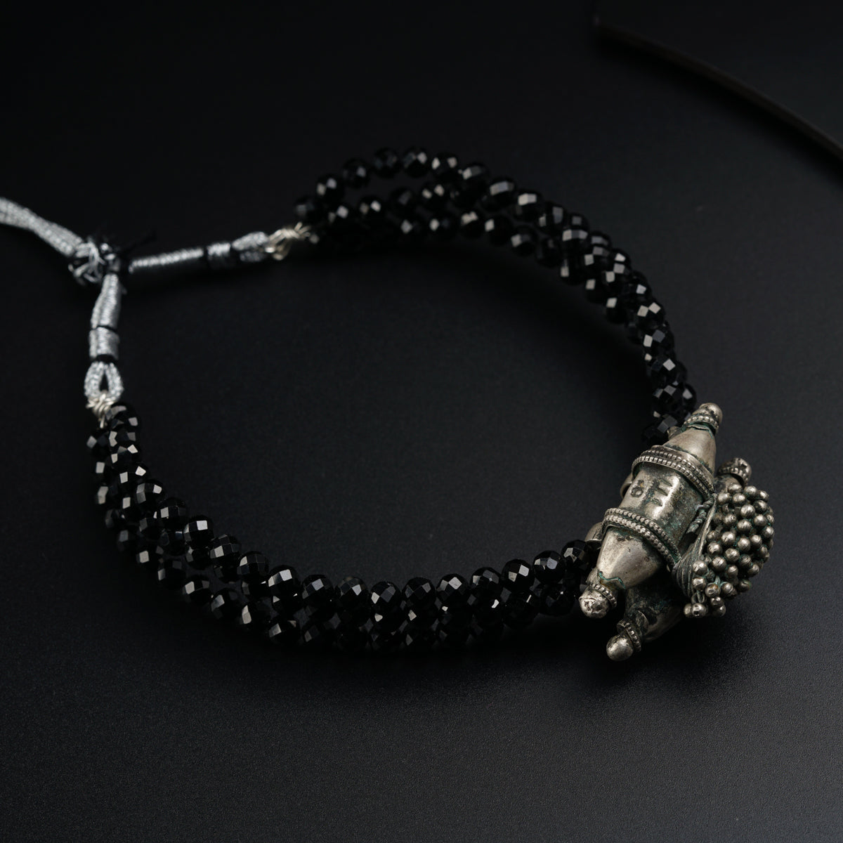 a black beaded bracelet with an elephant head charm