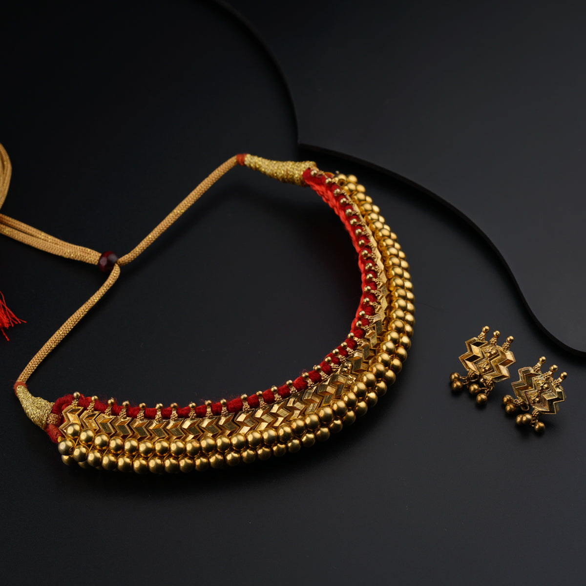 a necklace and a pair of earrings on a black surface