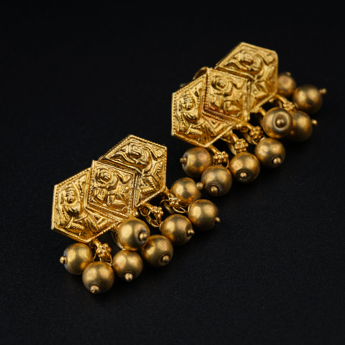 a close up of a pair of gold earrings