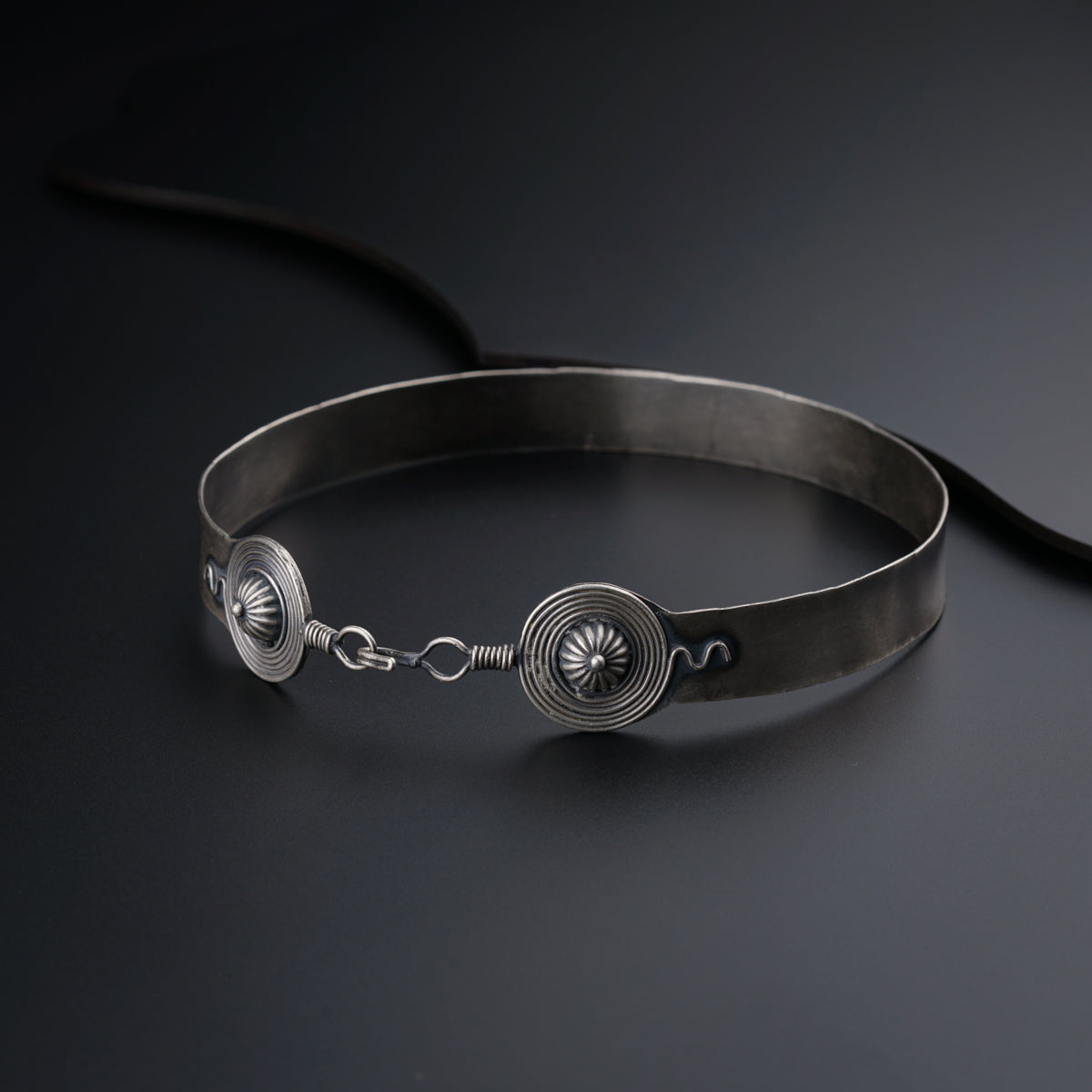 a metal bracelet with a flower on it