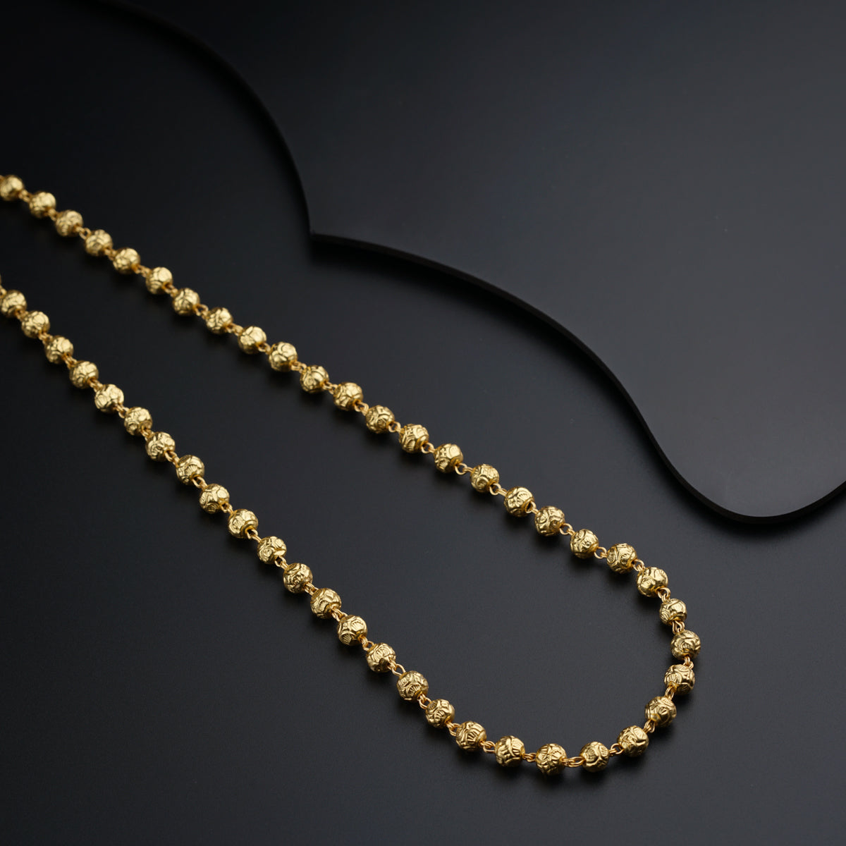 a gold chain on a black surface