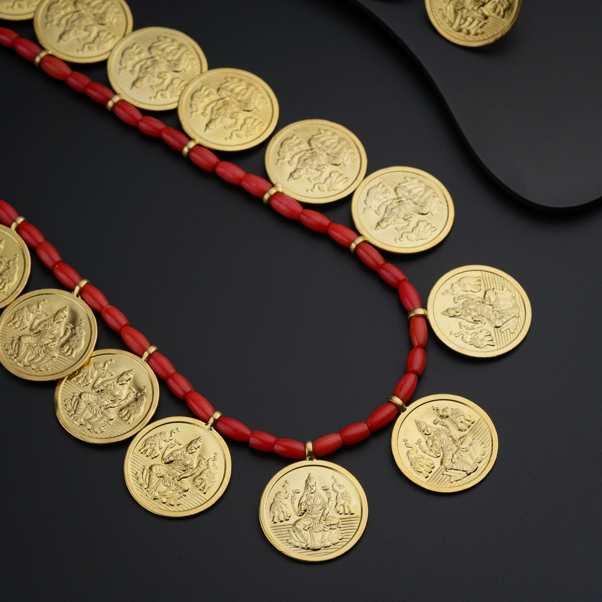a red necklace with gold coins on it