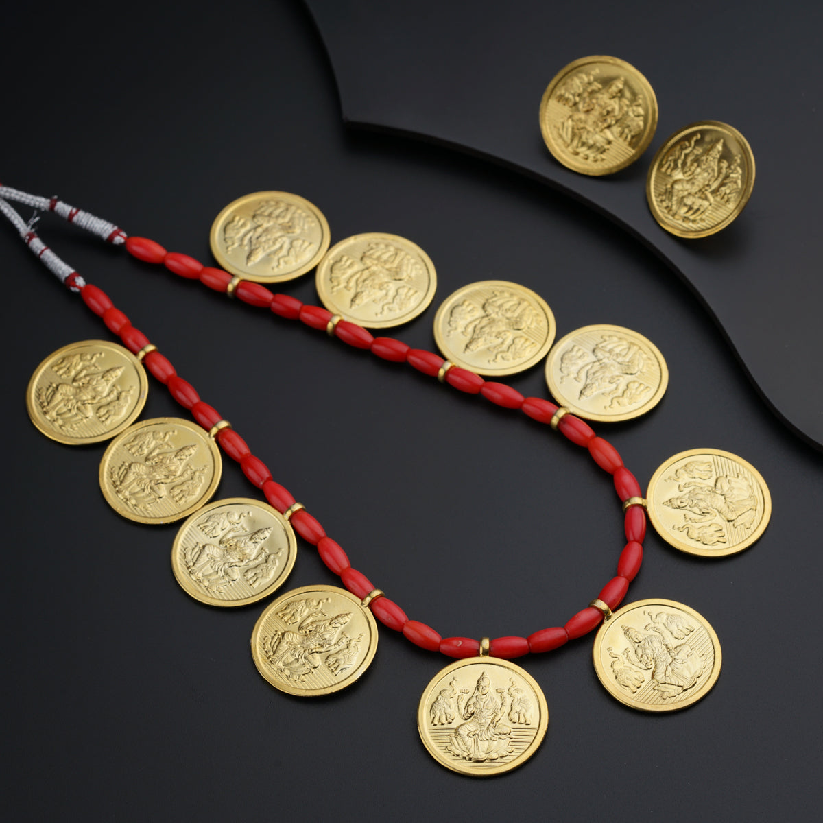 a necklace of gold coins with a red cord