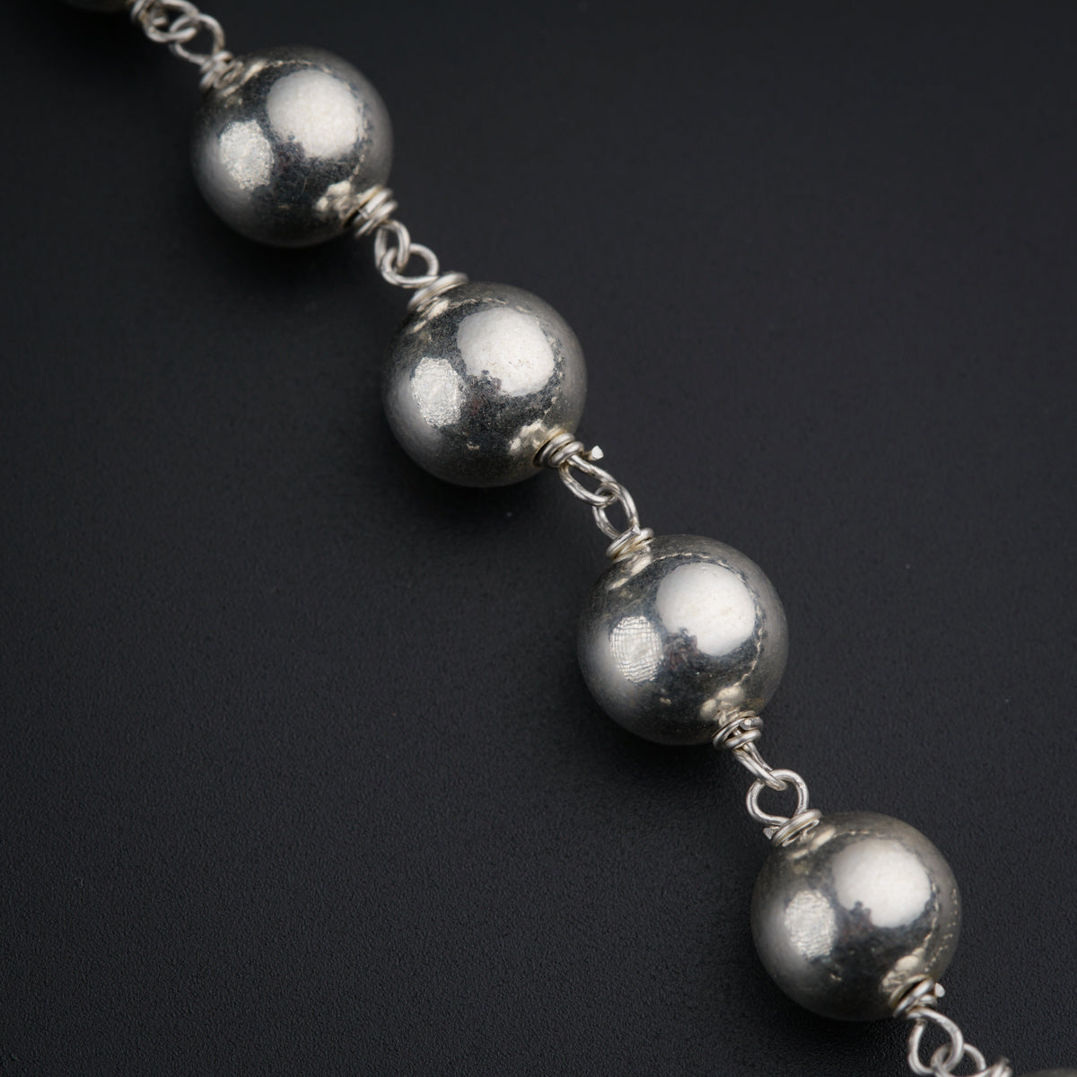 a close up of a chain with balls on it
