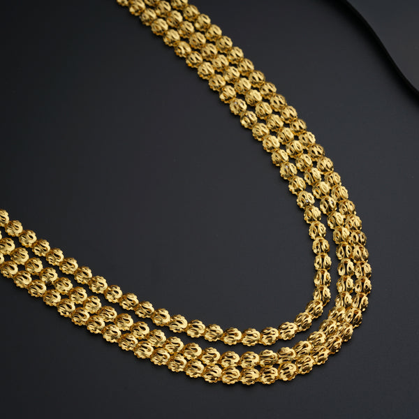 a close up of a gold chain on a black surface