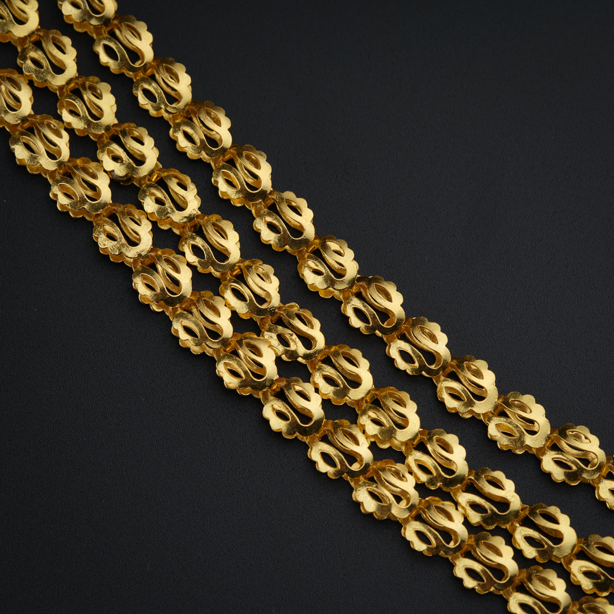 a close up of a gold chain on a black background