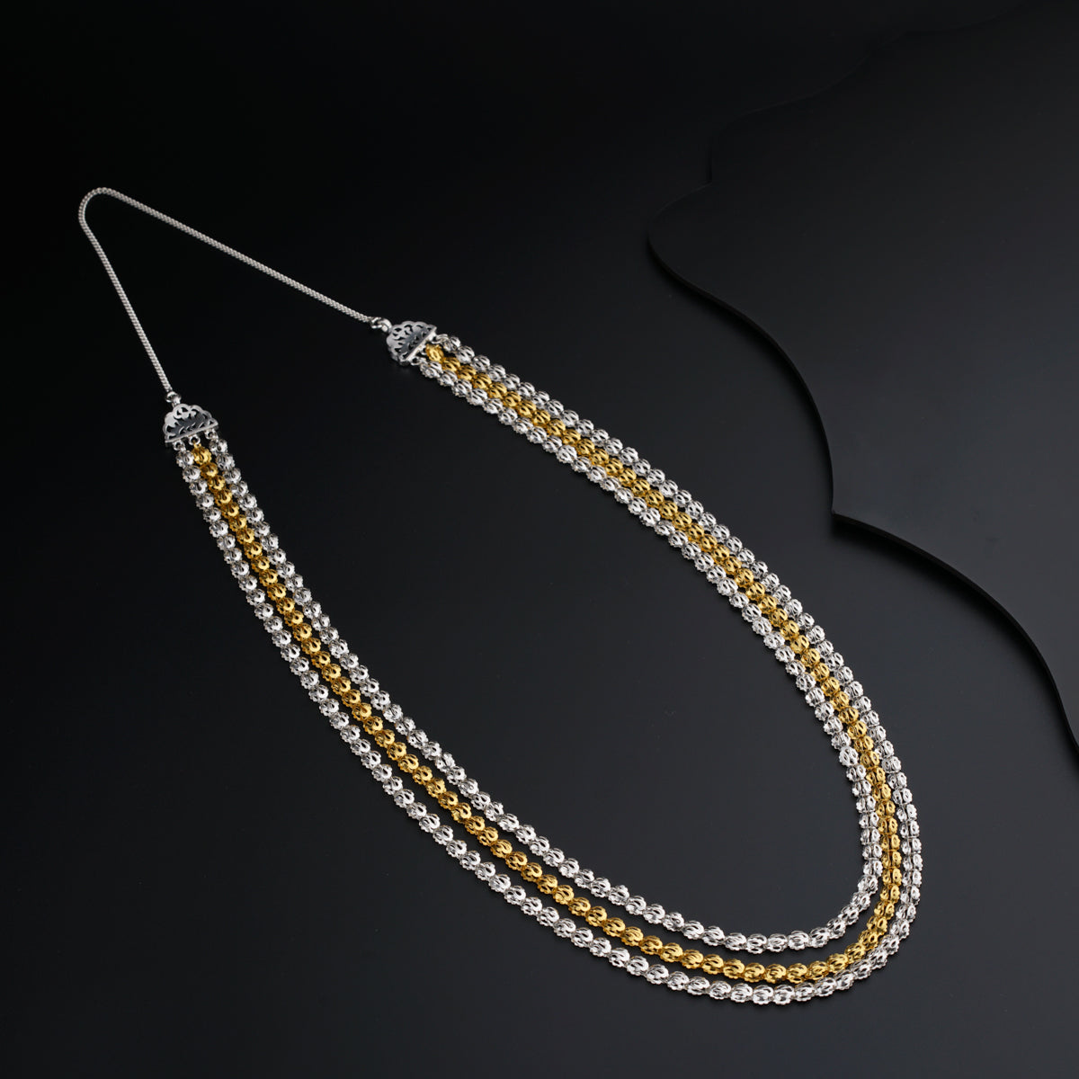 a close up of a necklace on a black surface