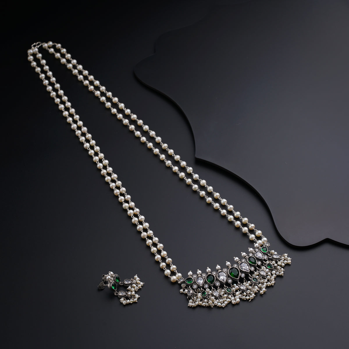 a necklace and earring set with pearls and emeralds