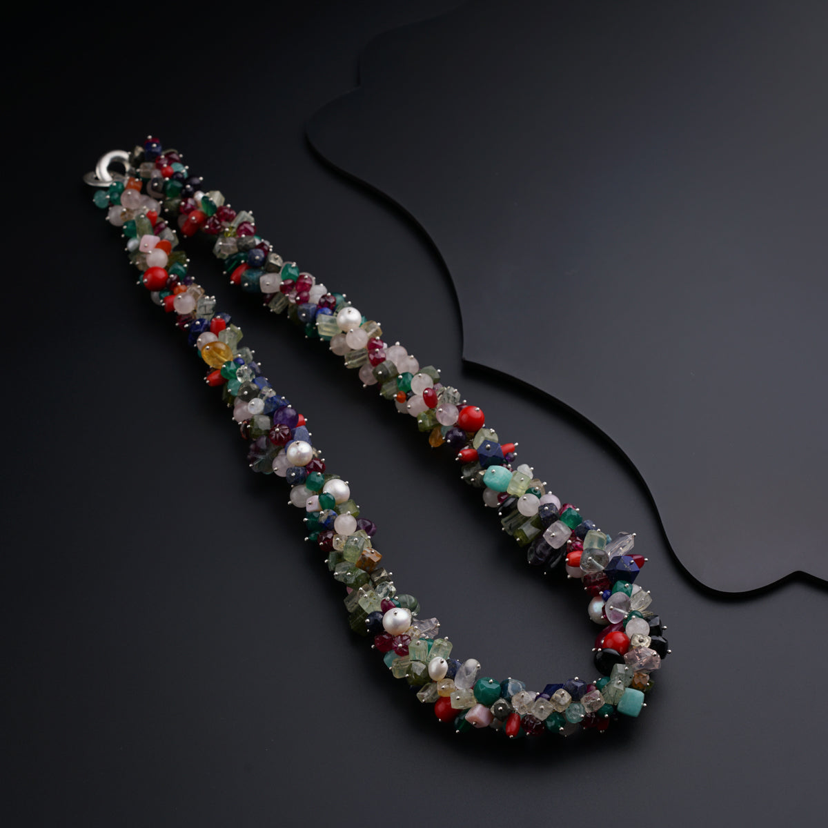 a multicolored beaded necklace on a black surface