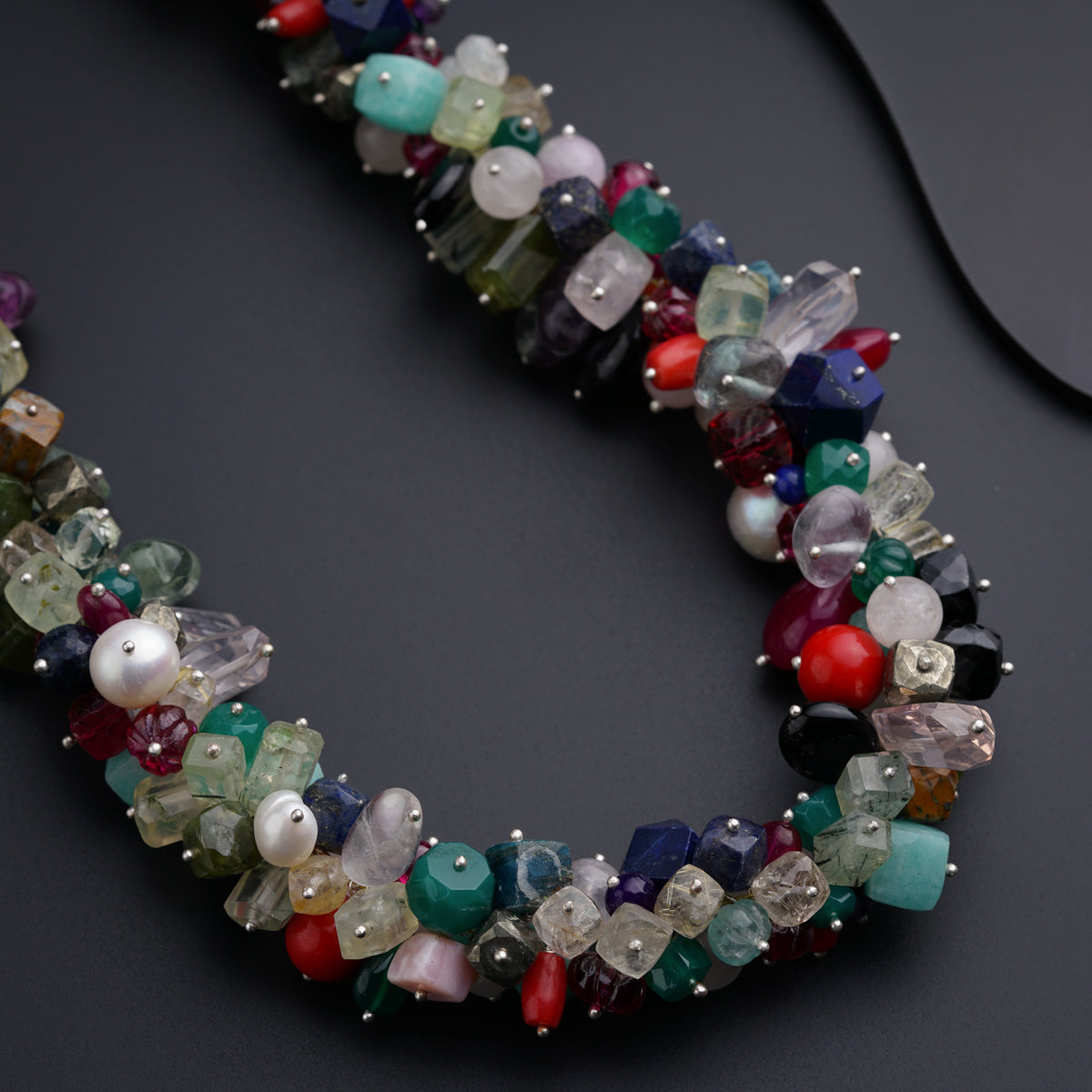 a multi - colored beaded necklace on a black surface