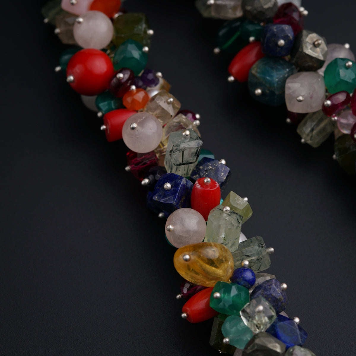 a close up of a beaded bracelet on a black surface