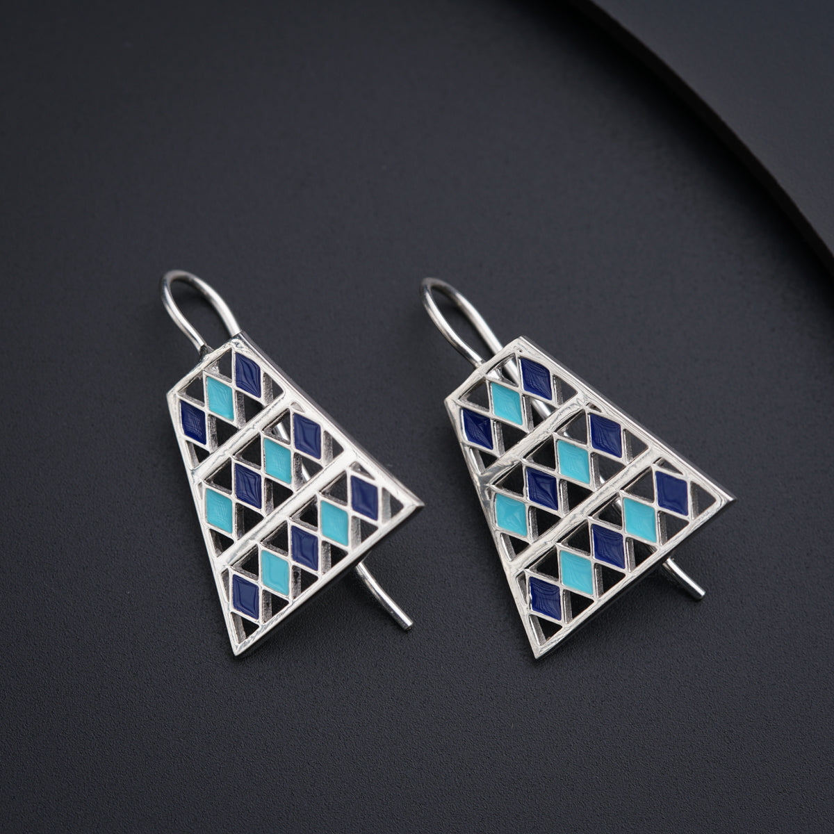 a pair of blue and white earrings on a black surface