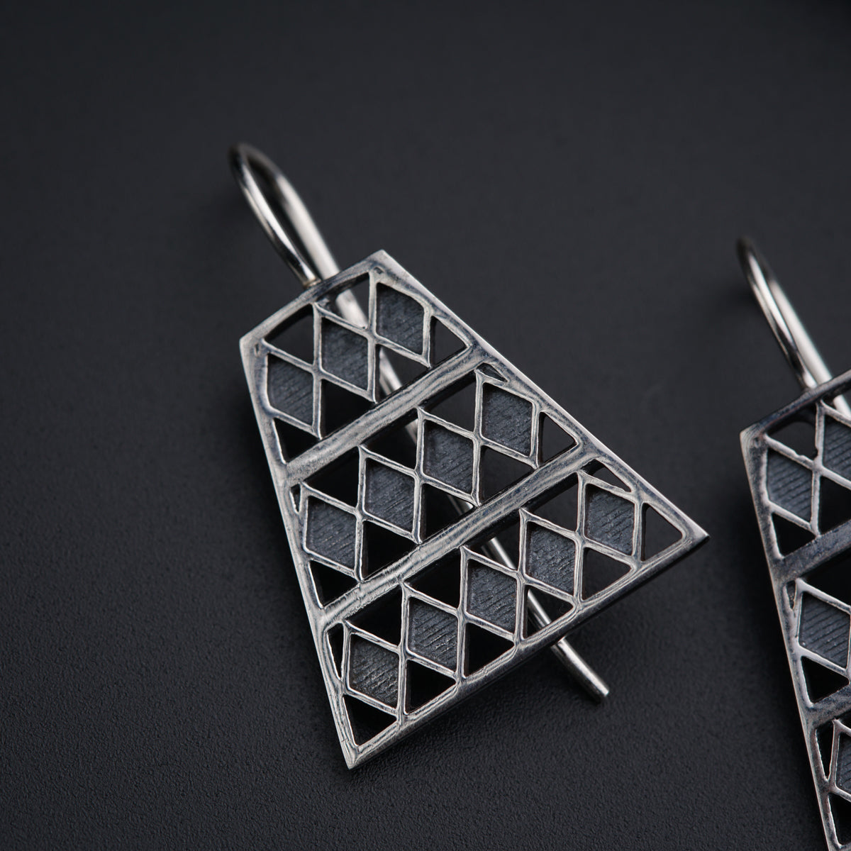 a pair of earrings on a black surface