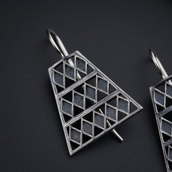 a pair of earrings on a black surface