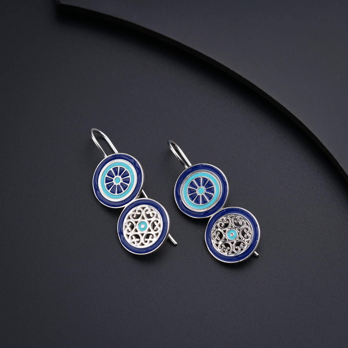 a pair of blue and white earrings sitting on top of a table
