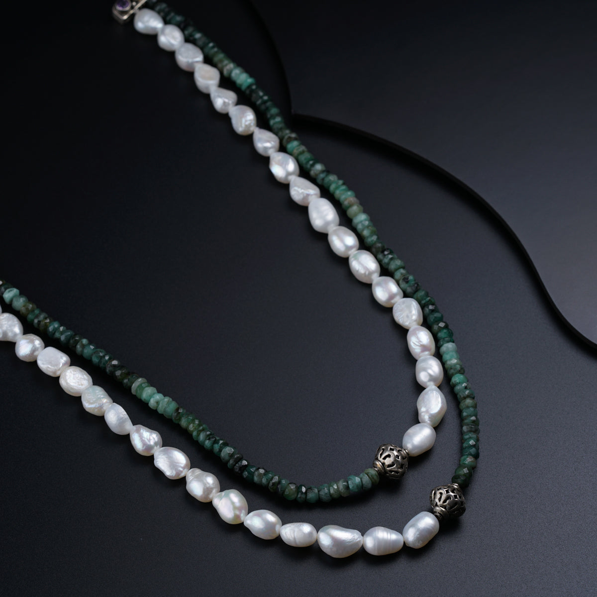 a long necklace with pearls and green beads