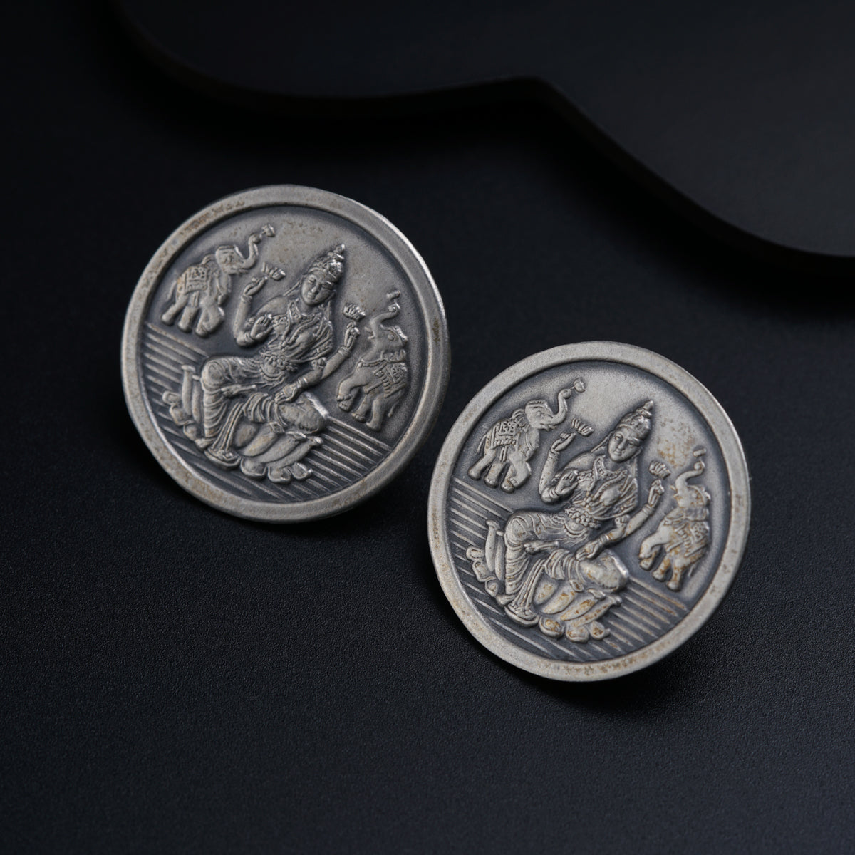 a close up of two metal buttons on a black surface