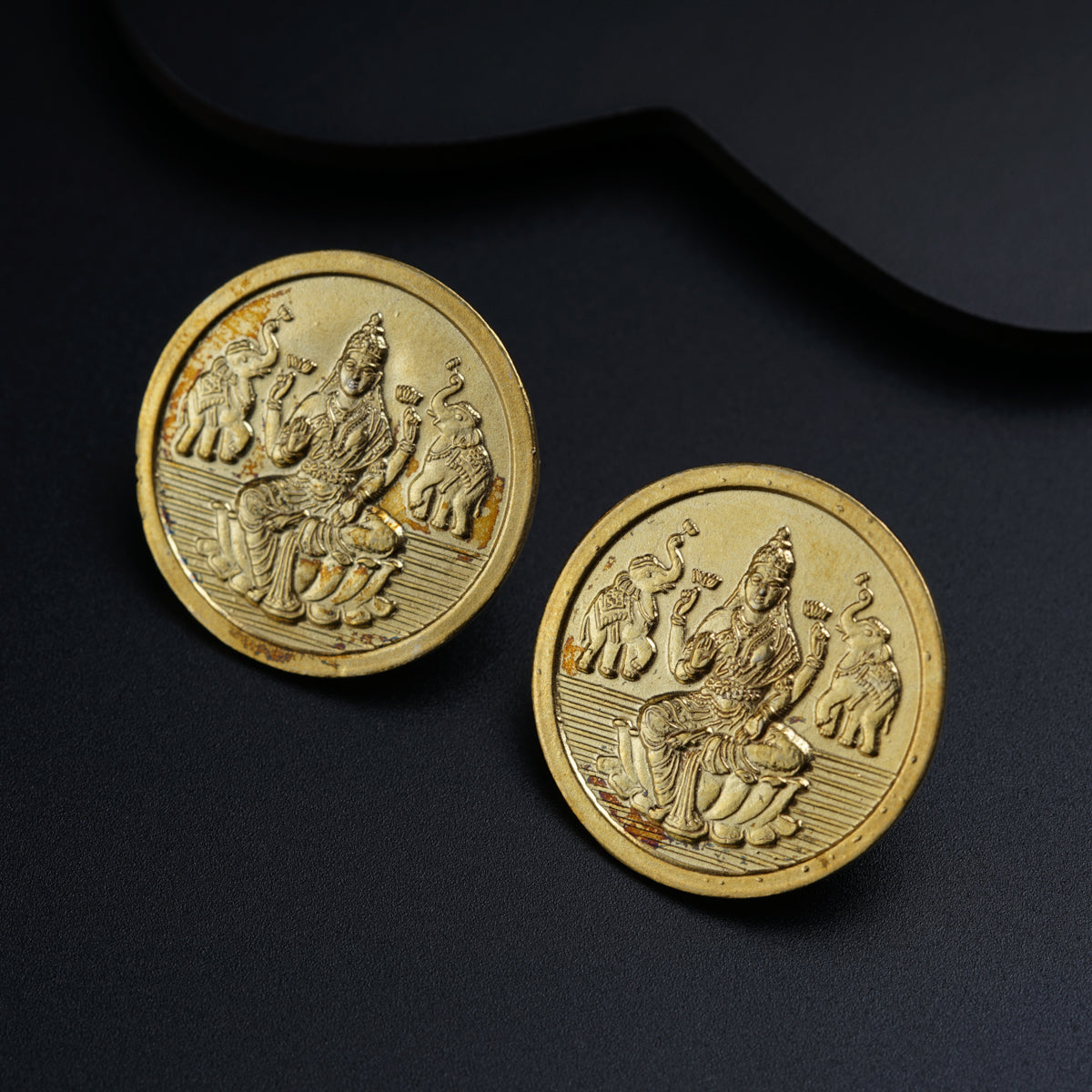 a pair of gold coins sitting on top of a table
