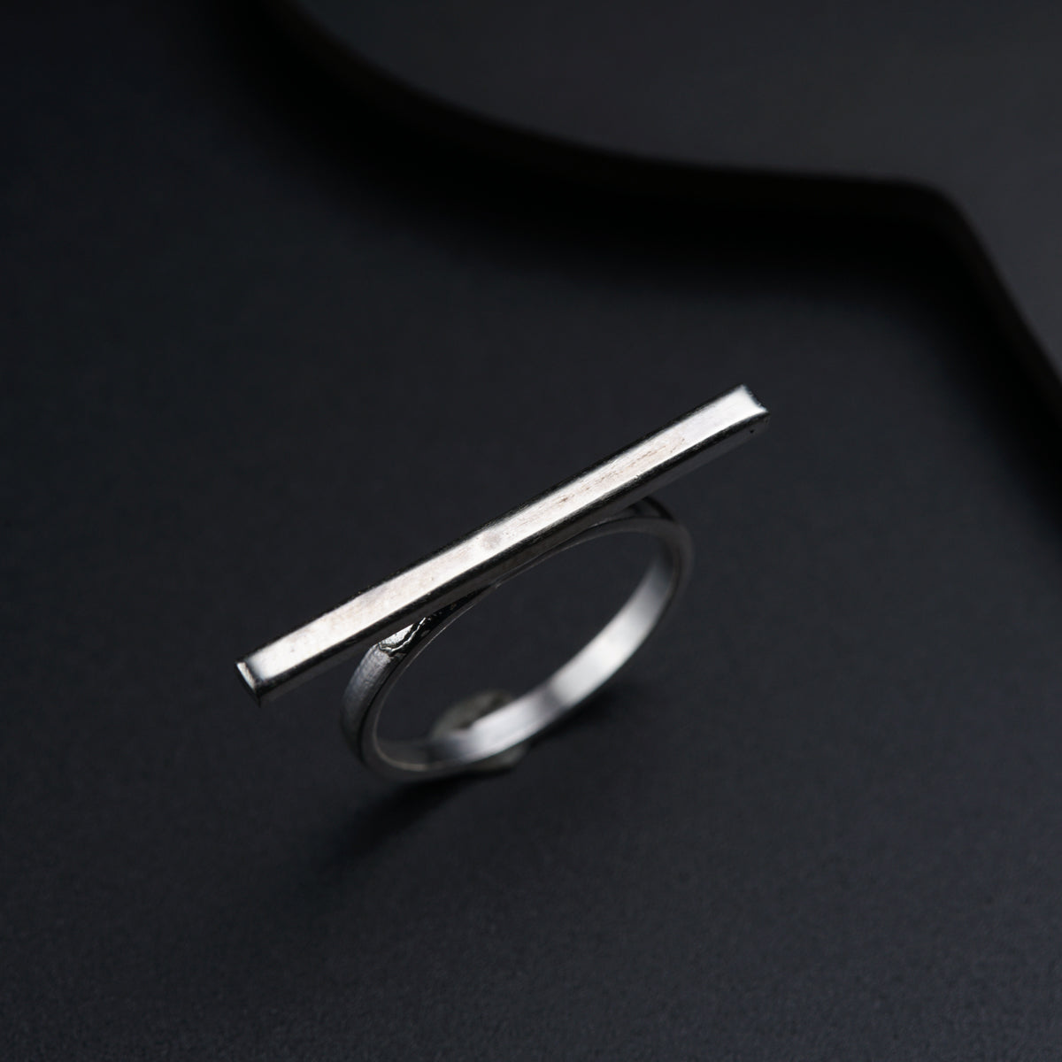 a silver ring with a thin bar on top of it