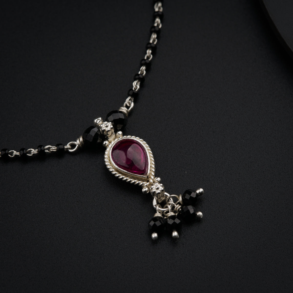 a necklace with a heart shaped pendant on a black surface