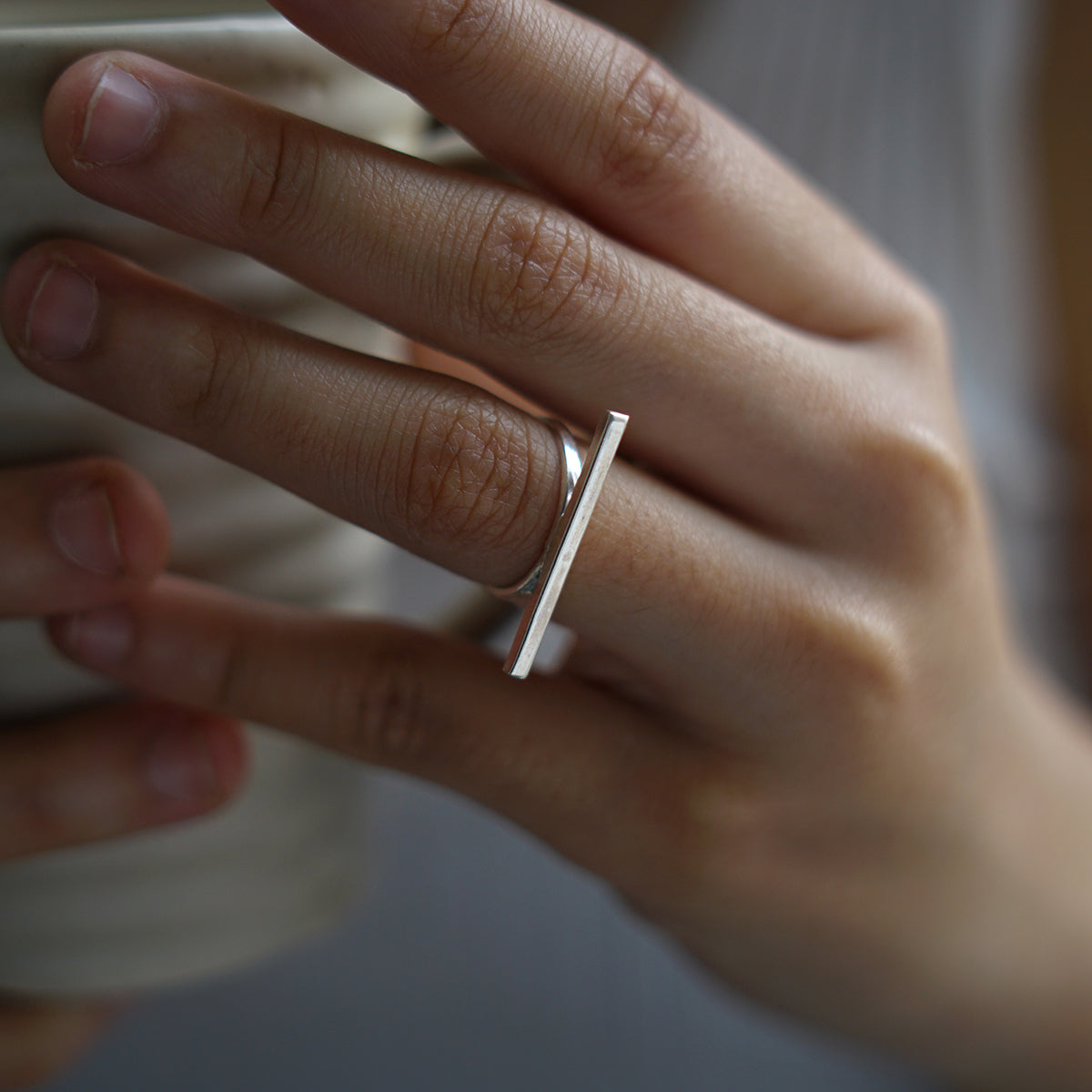 a woman's hand holding a cup of coffee