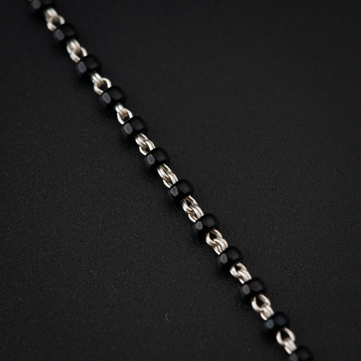 a close up of a chain on a black surface