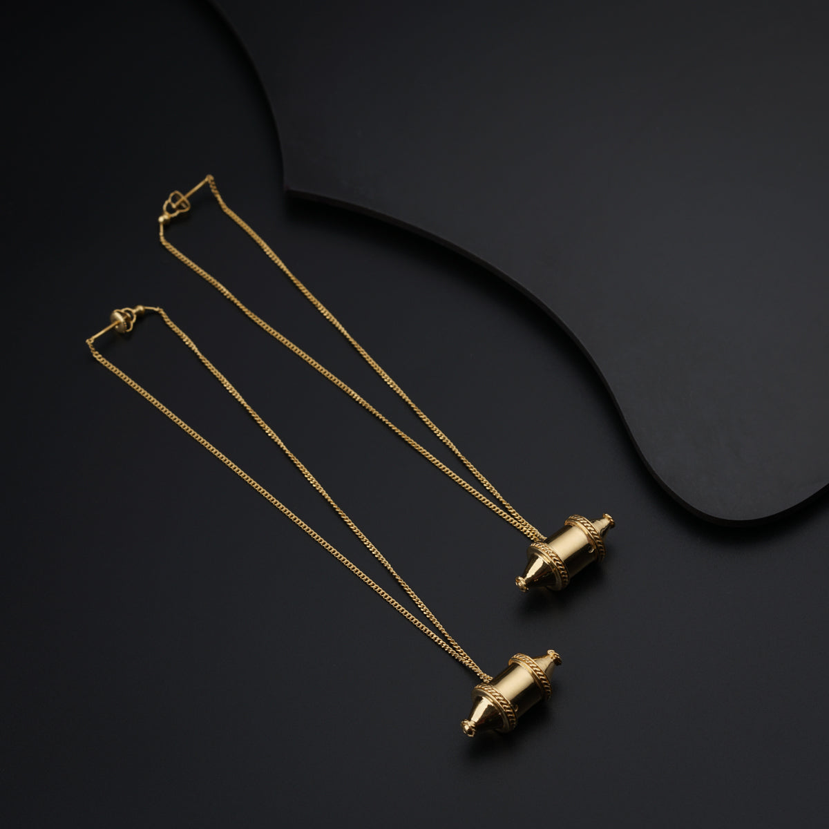 a pair of necklaces on a black surface